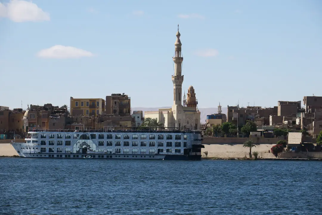 Un bateau de croisière navigue sur le Nil près d'une mosquée à Assouan, en Égypte