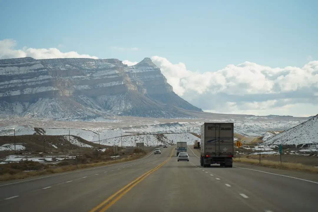 Un road trip hivernal à travers un terrain montagneux avec des véhicules sur une autoroute panoramique