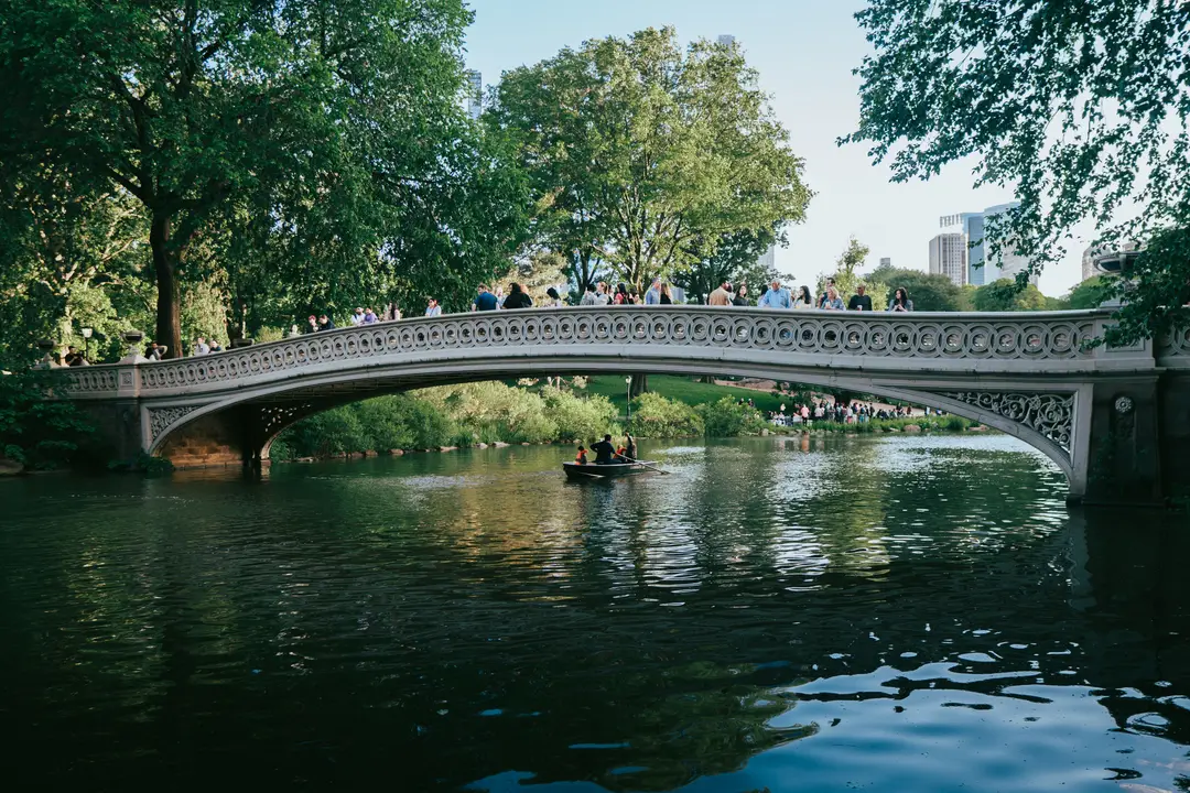 Une scène pittoresque du Bow Bridge avec des gens et un bateau à Central Park, à New York.