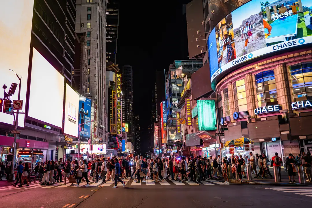 Une vue animée de Times Square la nuit avec des foules animées, des panneaux d'affichage lumineux et des monuments emblématiques