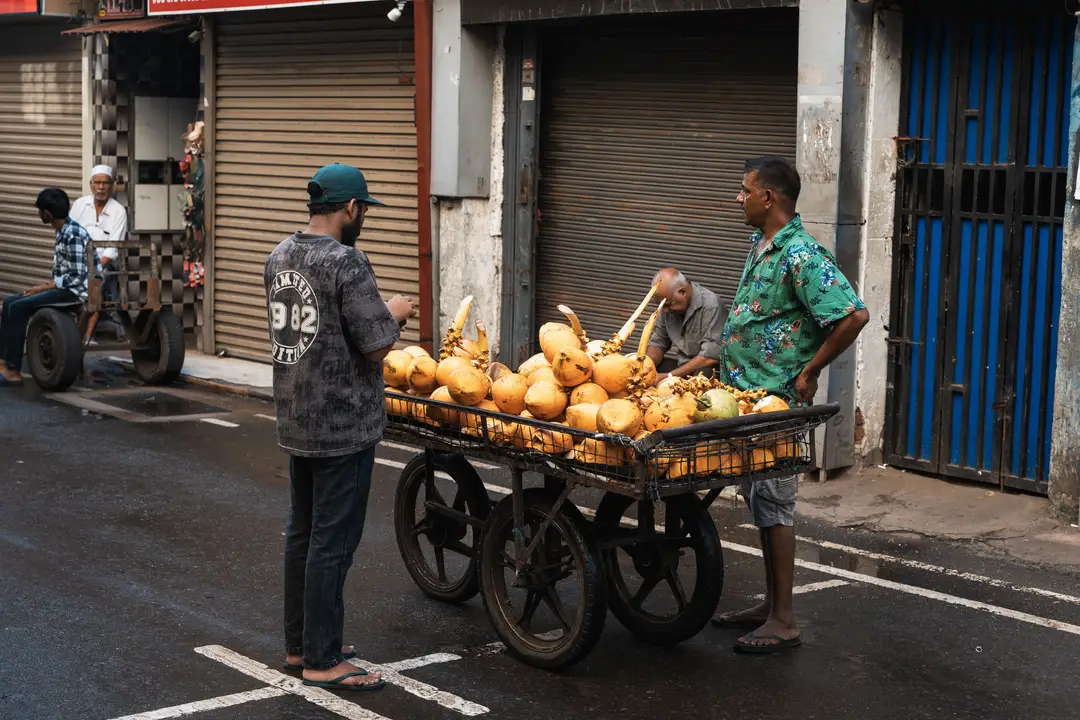 Vendeur de rue avec un chariot vendant des noix de coco à Pettah, Colombo, Sri Lanka