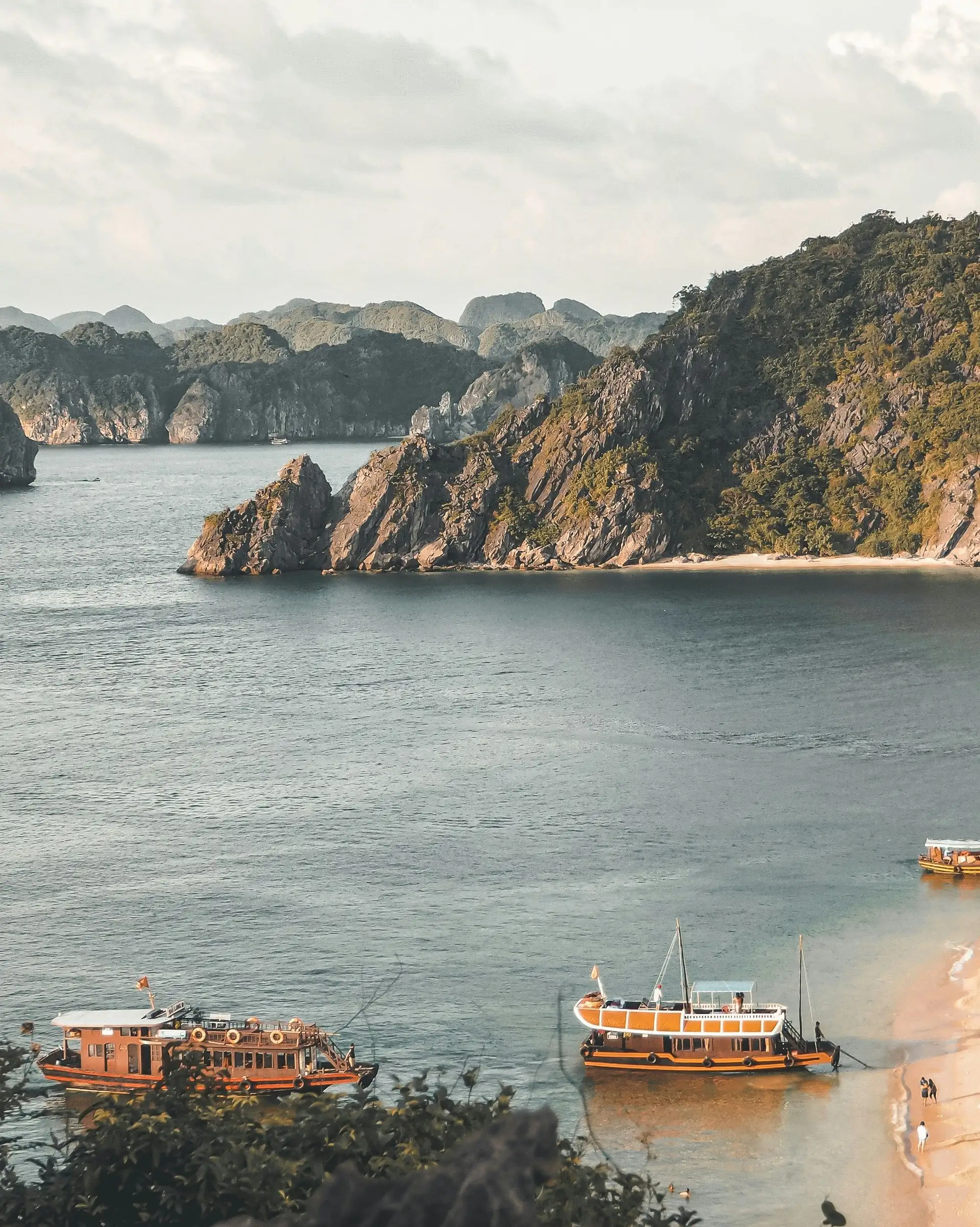 Voyage au Vietnam — Vue panoramique de la Baie d’Ha Long avec ses îlots karstiques et des bateaux traditionnels dans une eau calme.