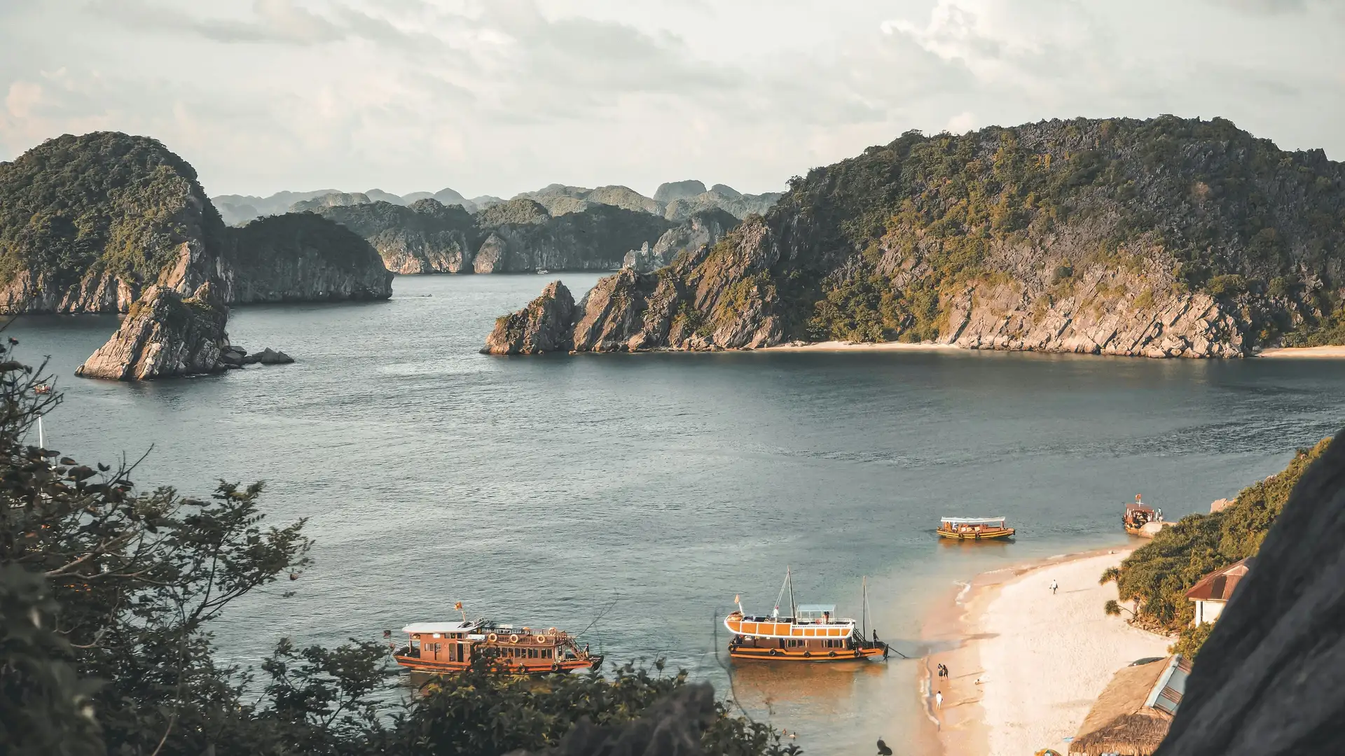 Voyage au Vietnam — Vue panoramique de la Baie d’Ha Long avec ses îlots karstiques et des bateaux traditionnels dans une eau calme.