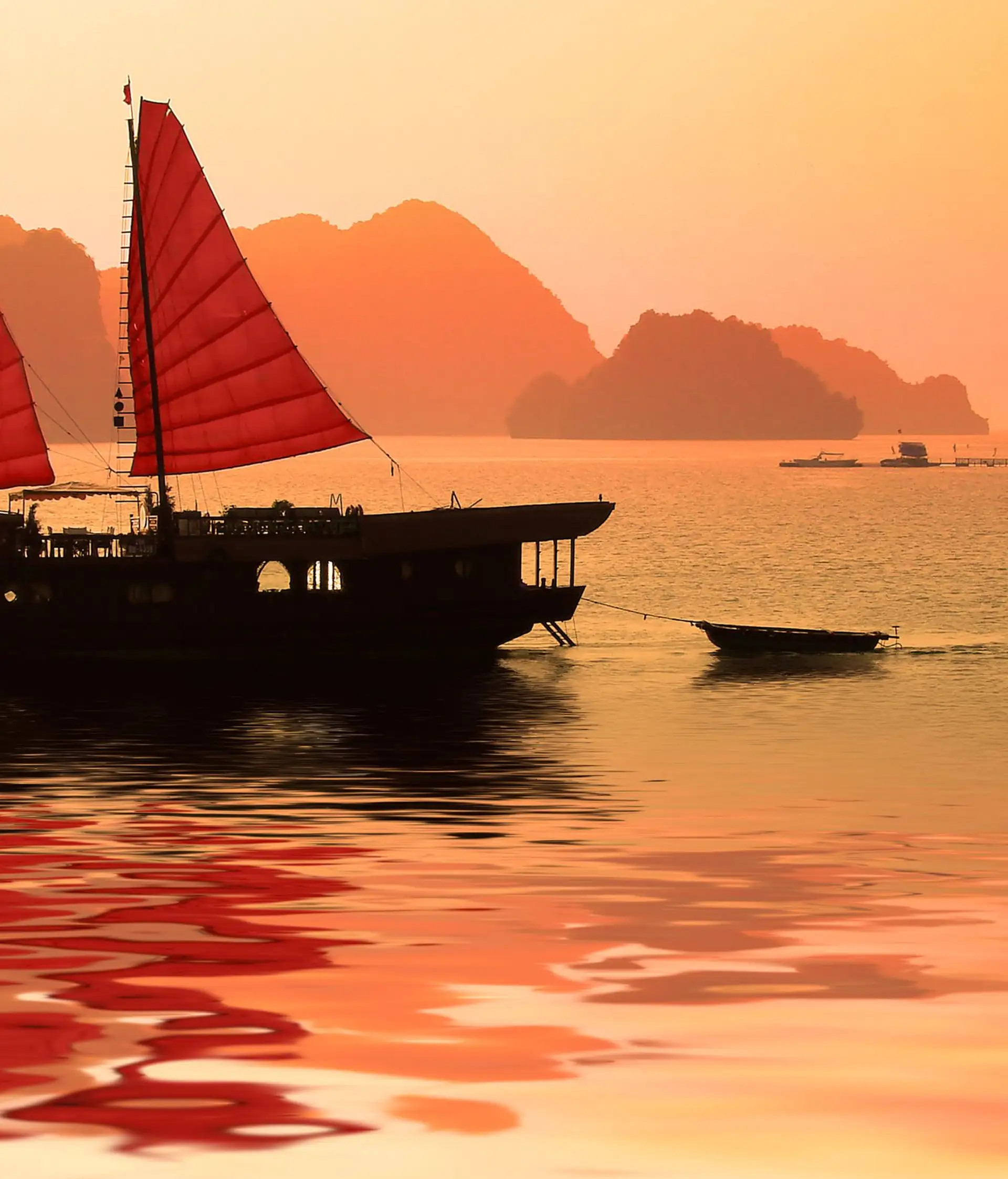 La baie d'Halong rouge-orangée au coucher du soleil au Vietnam