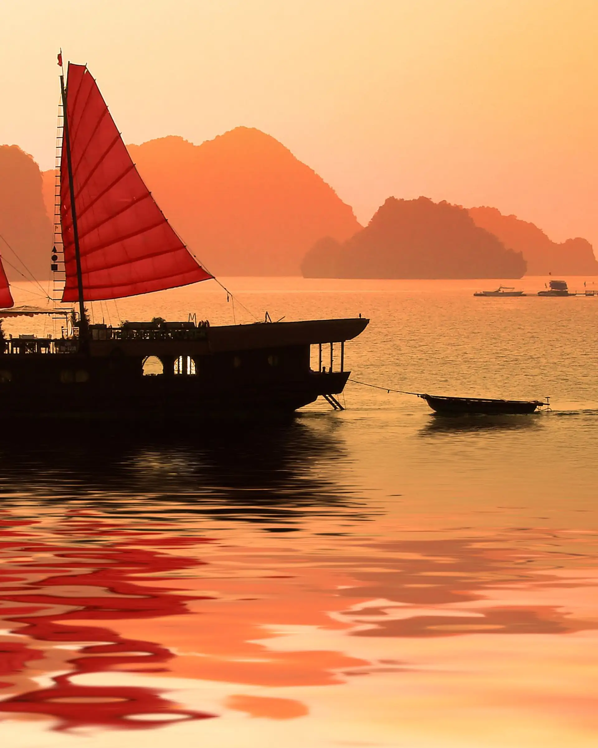 La baie d'Halong rouge-orangée au coucher du soleil au Vietnam