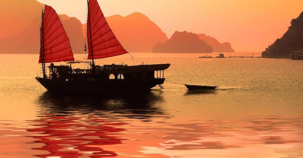 La baie d'Halong rouge-orangée au coucher du soleil au Vietnam