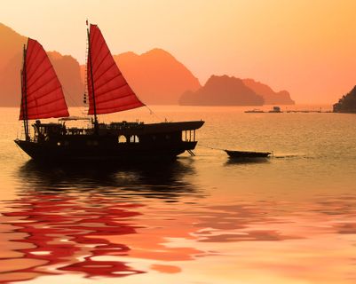 La baie d'Halong rouge-orangée au coucher du soleil au Vietnam