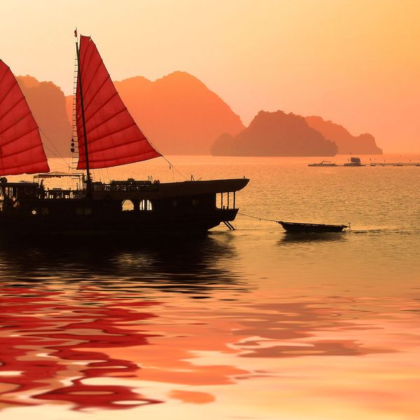 La baie d'Halong rouge-orangée au coucher du soleil au Vietnam
