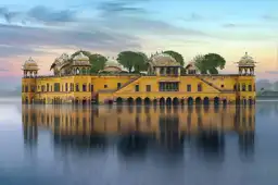 Voyage au Rajasthan – Le palais sur l'eau Jal Mahal et son reflet symétrique sur le lac Man Sagar à Jaipur, Inde du Nord.