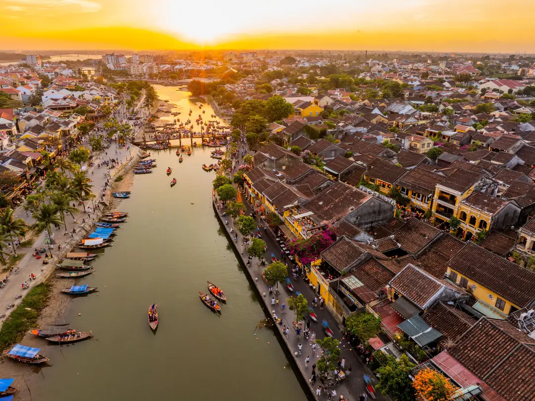 Vue aérienne impressionnante de Hội An avec des bateaux et la rivière Thu Bồn au coucher de soleil.jpg