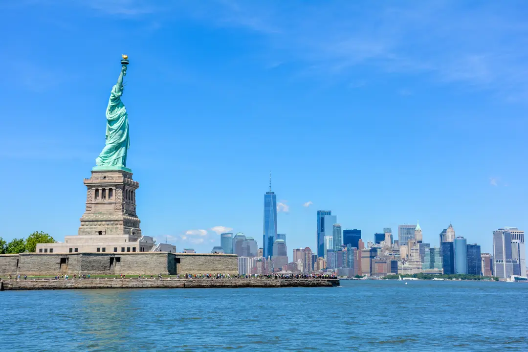 Vue de la Statue de la Liberté contre la silhouette de New York et un ciel bleu dégagé