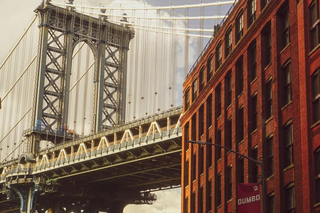 Vue de la Pont de Manhattan adjacent à un bâtiment en briques rouges à DUMBO, Brooklyn.