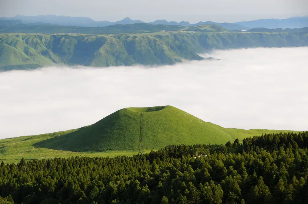 Vue imprenable d'une colline verte au milieu de nuages ondulants à Aso, Japon..jpg