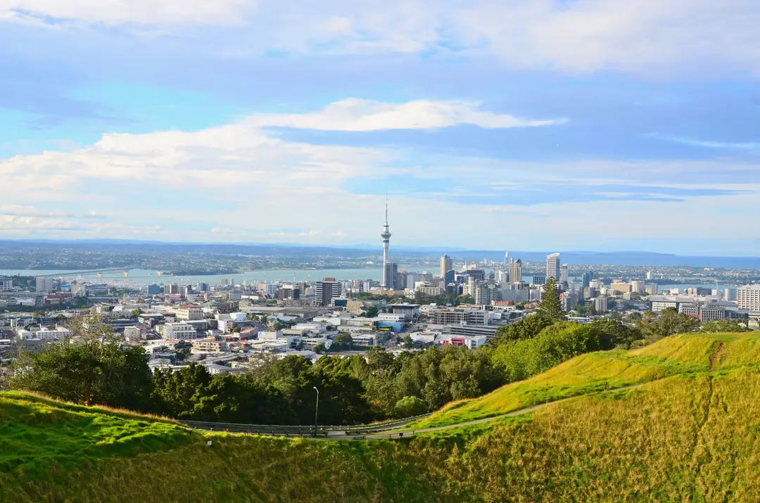 Vue sur Auckland avec la Sky Tower et les collines environnantes sous un ciel clair