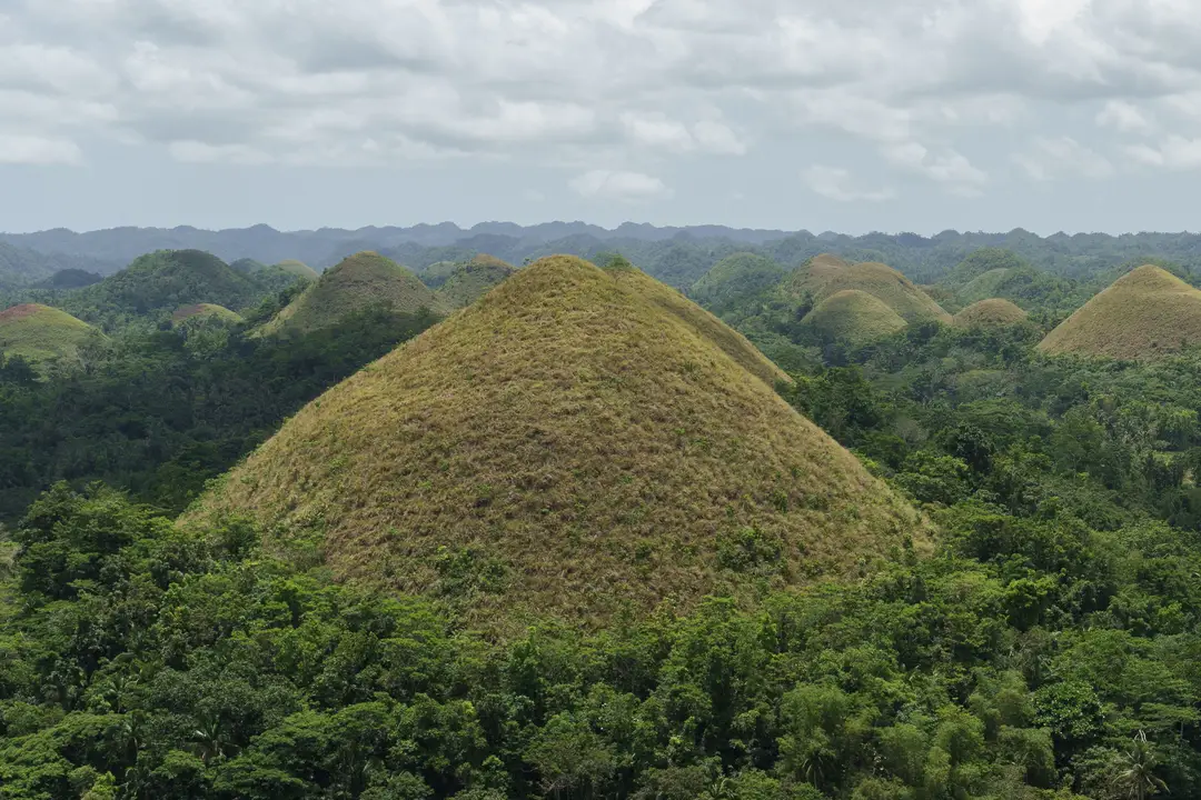 Vue panoramique des célèbres Chocolate Hills à Bohol, Philippines, sous un ciel nuageux.jpg