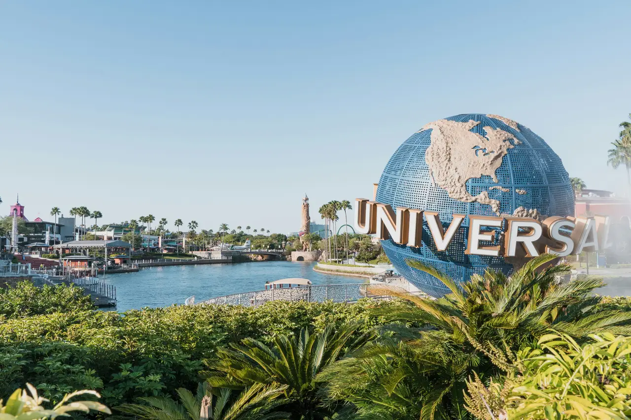 Célèbre globe terrestre géant rotatif Universal Studios devant un bassin d'eau sous un ciel dégagé à Orlando