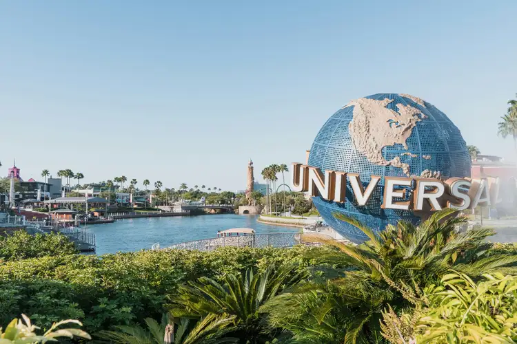 Célèbre globe terrestre géant rotatif Universal Studios devant un bassin d'eau sous un ciel dégagé à Orlando