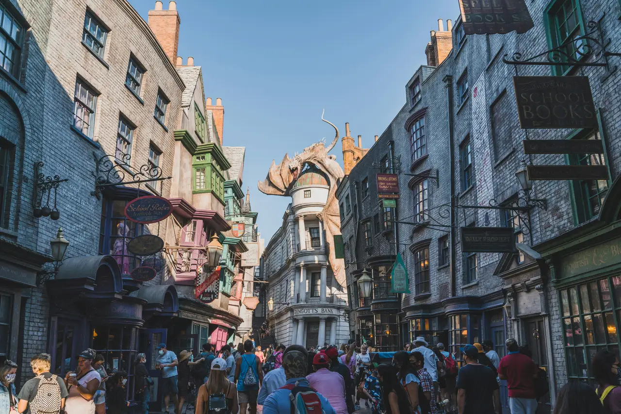 Ruelle pavée animée du Chemin de Traverse dominée par un dragon perché sur un toit dans un parc d'attractions à Orlando
