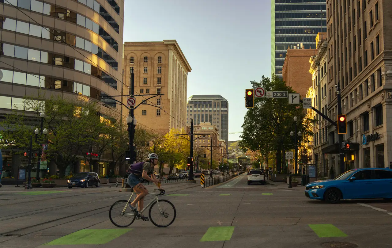 Rue du centre-ville de Salt Lake City bordée d'immeubles modernes et historiques avec des voies de tramway sous une lumière de fin de journée