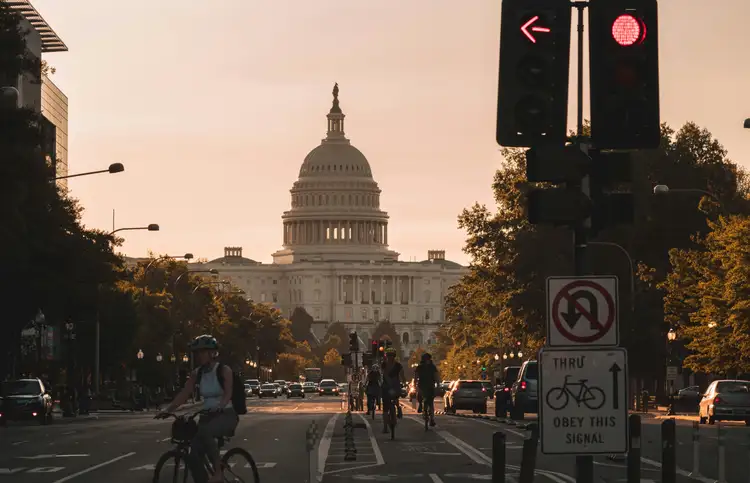 Dôme du Capitole des États-Unis visible en perspective depuis une avenue urbaine au crépuscule à Washington DC