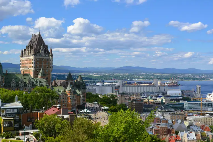Vue panoramique sur le prestigieux Fairmont Le Château Frontenac dominant la ville de Québec et le fleuve Saint-Laurent sous un ciel ensoleillé