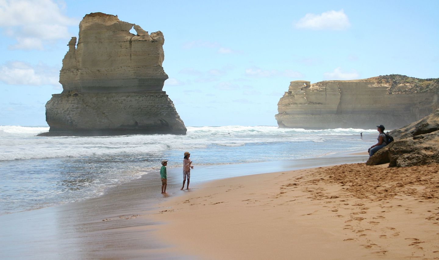 Enfants jouant sur la plage devant les falaises des Douze Apôtres