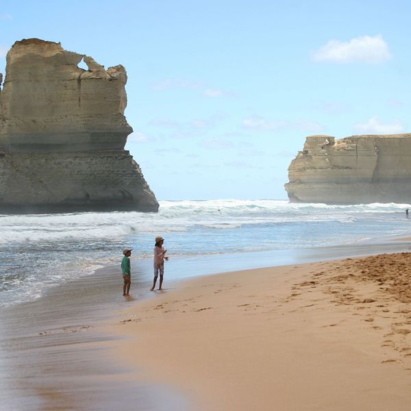 Enfants jouant sur la plage devant les falaises des Douze Apôtres