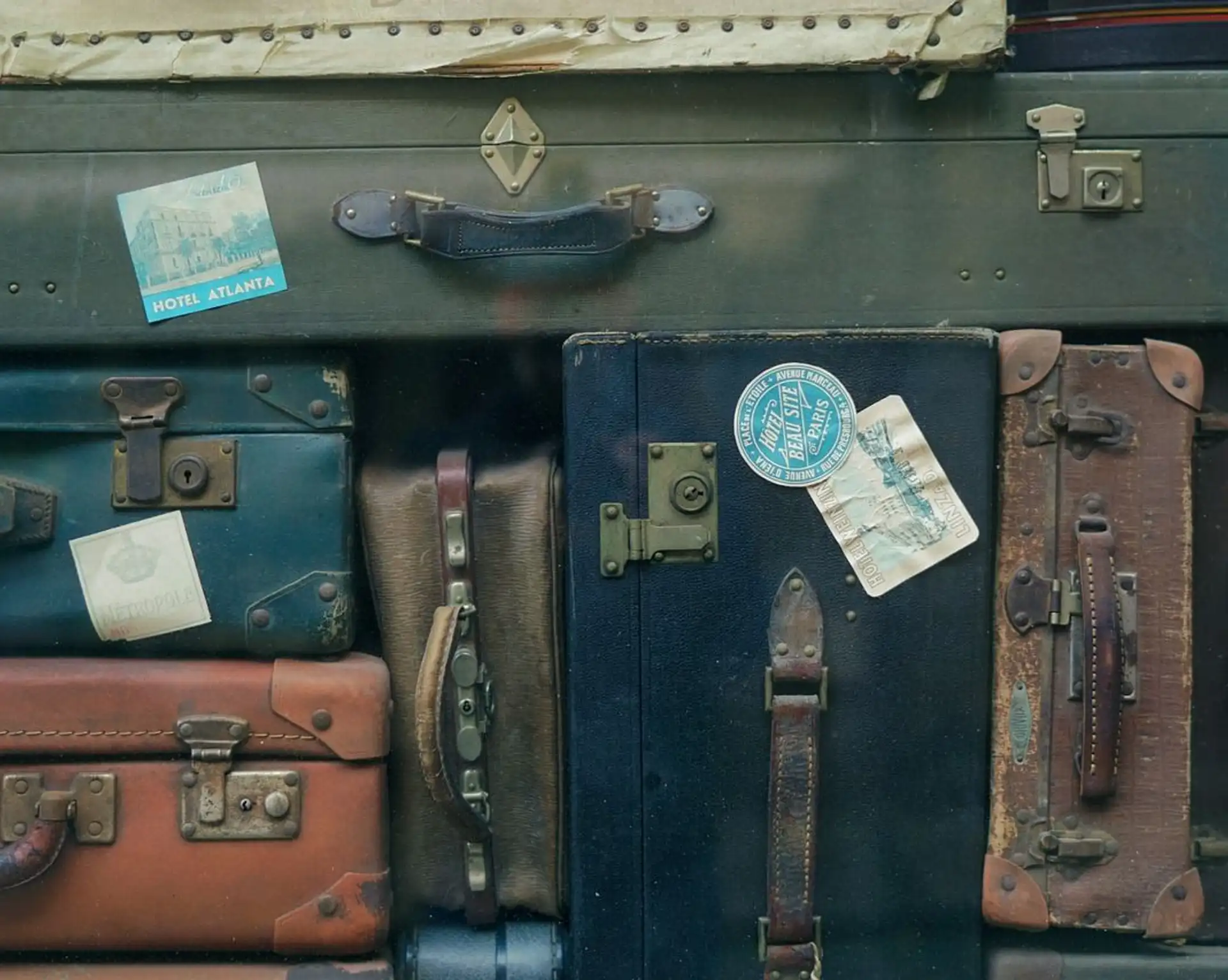 Pile de valises anciennes et vintage prêtes pour le départ lors d'un voyage en famille.