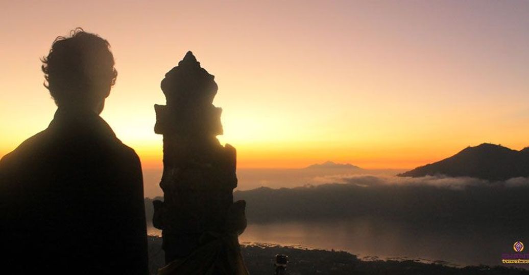 Travel in Asia - Man watching the sunrise from the summit of Mt. Batur in Bali