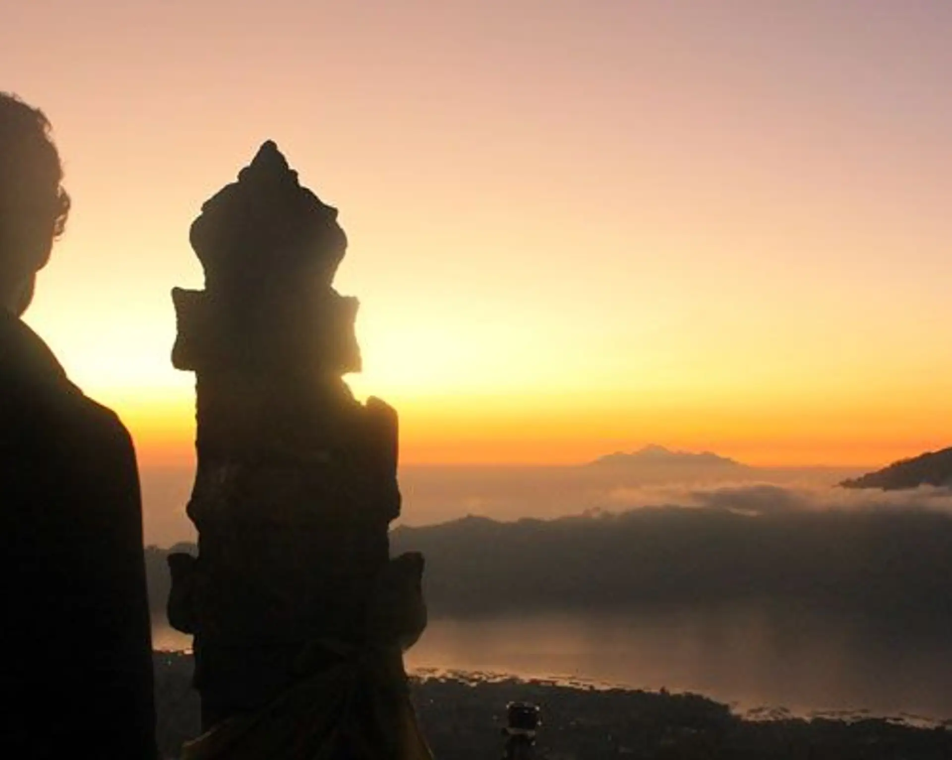 Travel in Asia - Man watching the sunrise from the summit of Mt. Batur in Bali