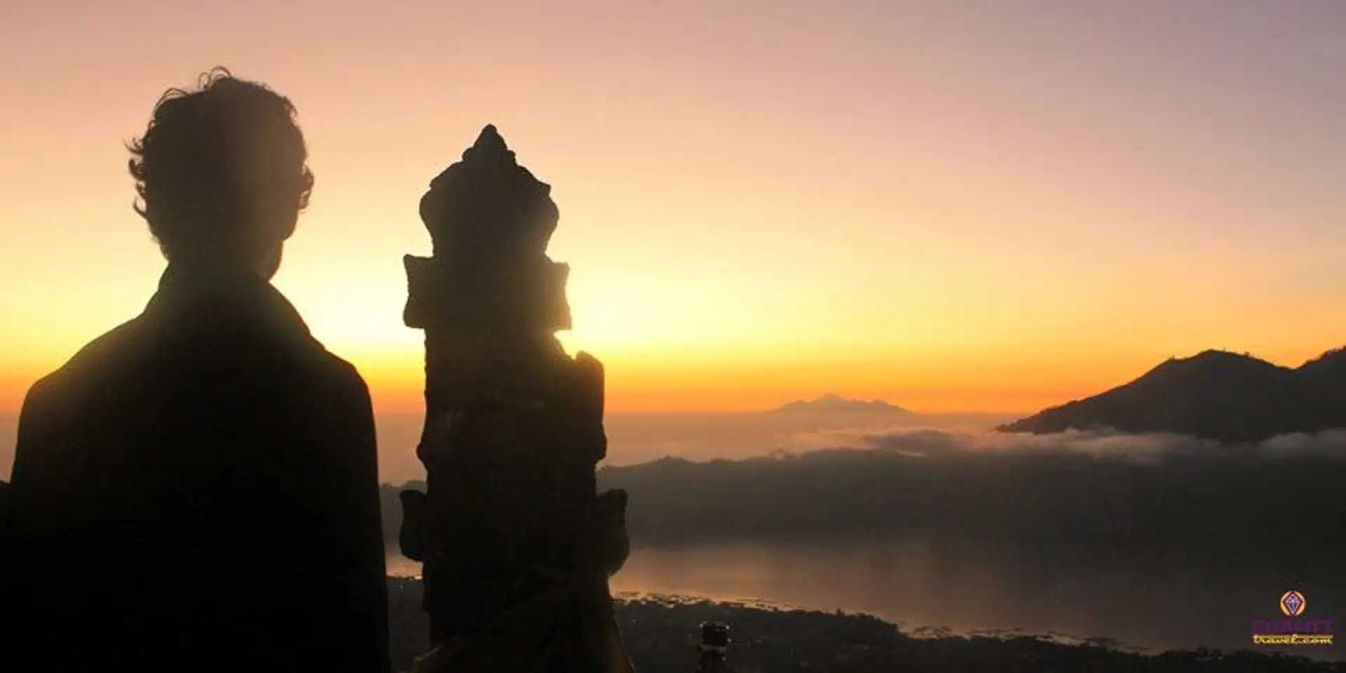 Travel in Asia - Man watching the sunrise from the summit of Mt. Batur in Bali