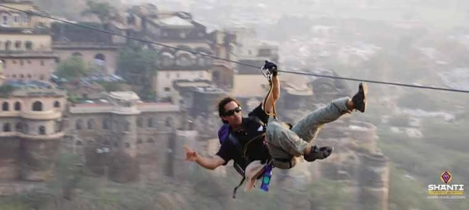 Travel in Asia - Man ziplining at the Neemrana at the Fort Palace in Rajasthan, India