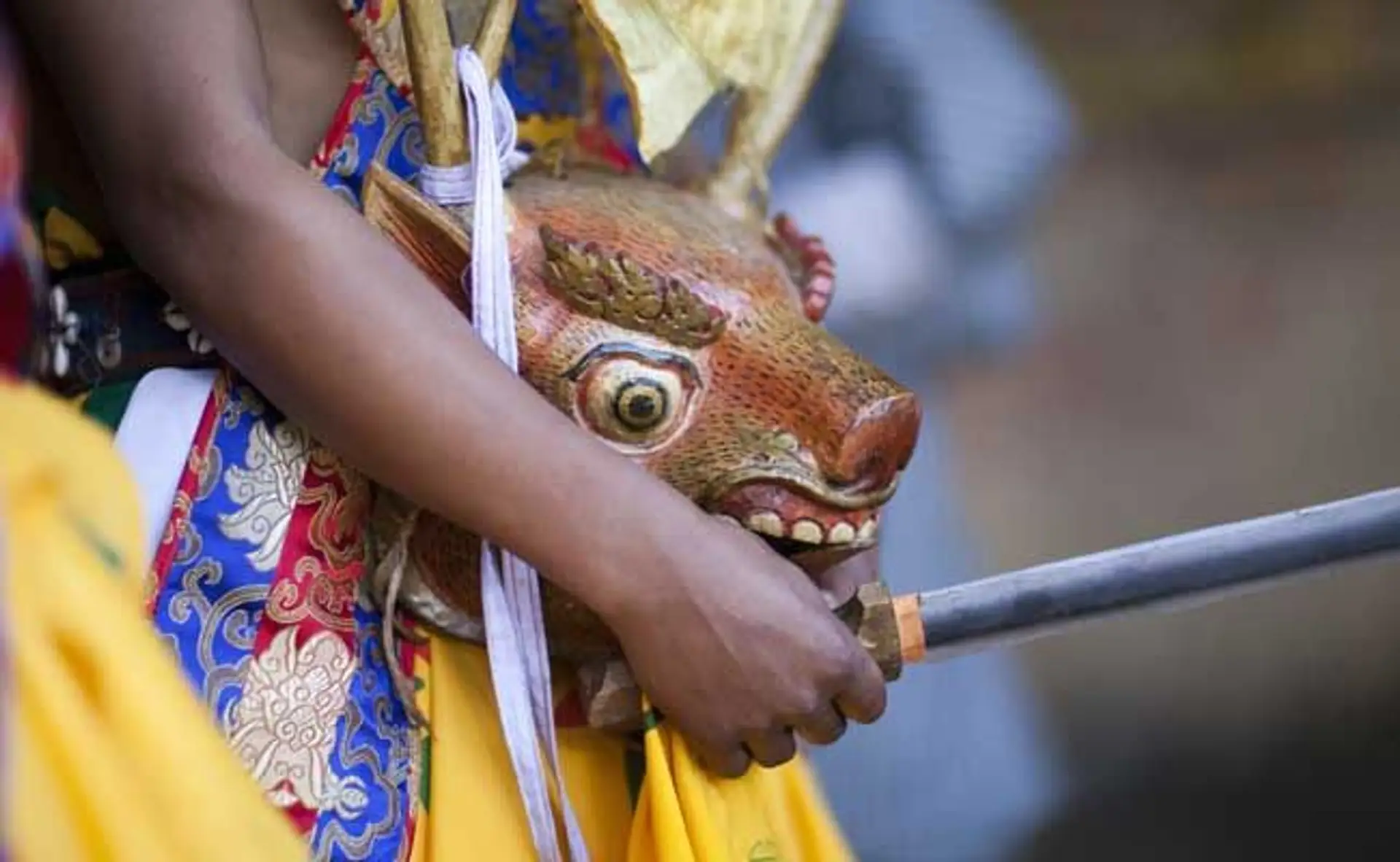 Travel in Asia - A child holding a traditional mask used in a tshechu festival in Bhutan