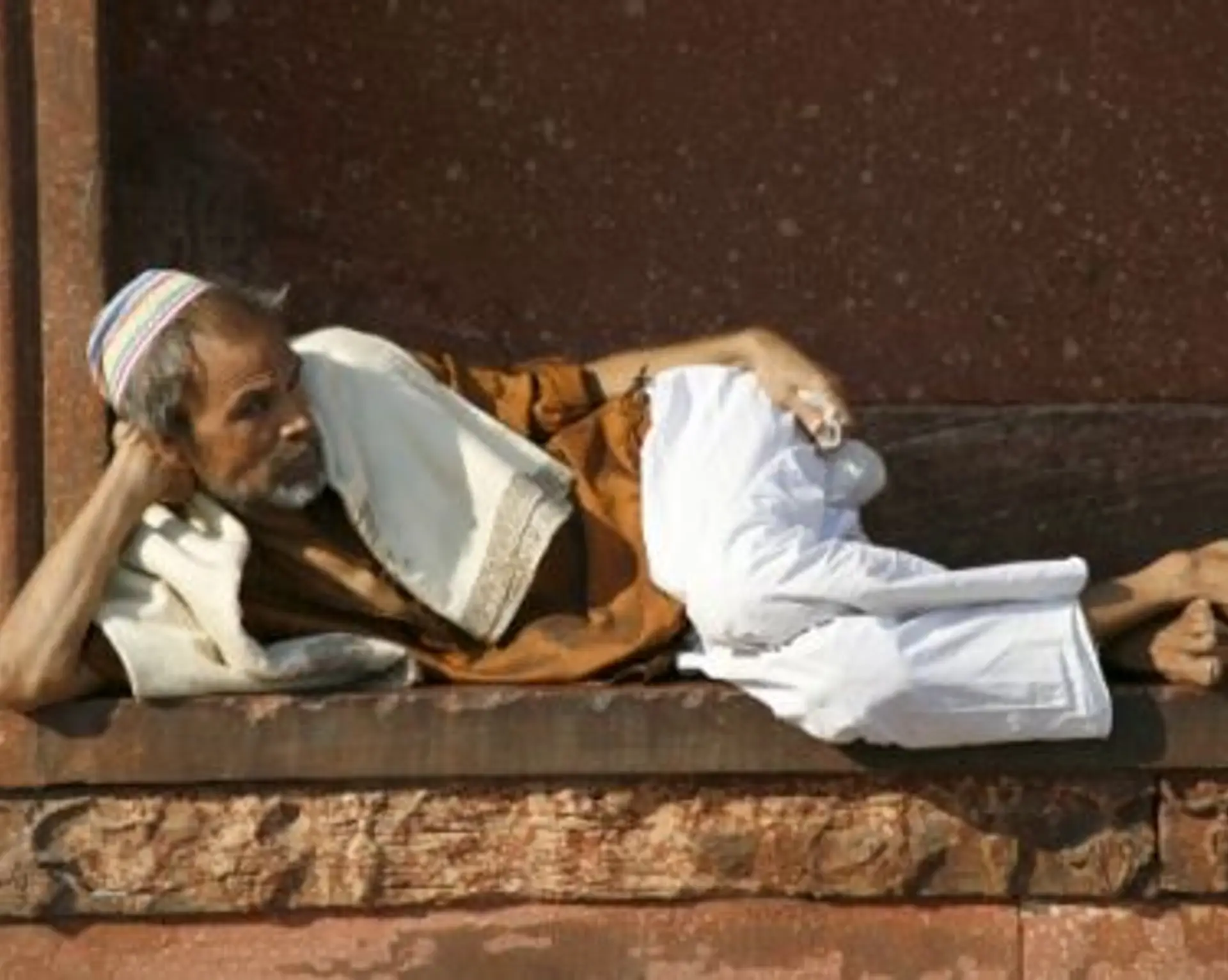 Travel in Asia - A man relaxing at the Jama Masjid in Delhi, India