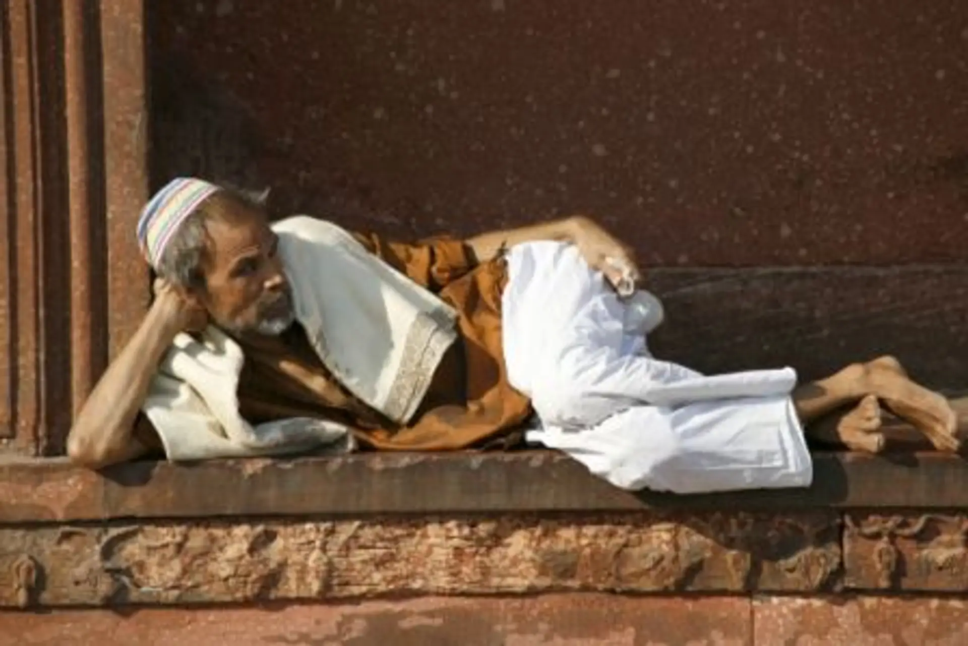 Travel in Asia - A man relaxing at the Jama Masjid in Delhi, India