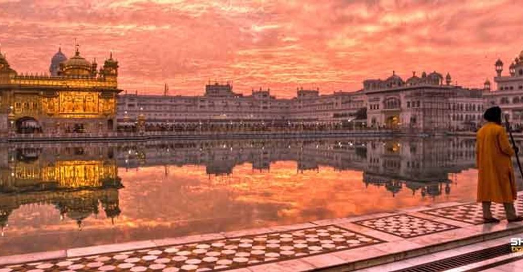 Travel in Asia - Man walking around the lake of the Harmandir Sahib, or Golden Temple, in Amritsar, Punjab, India