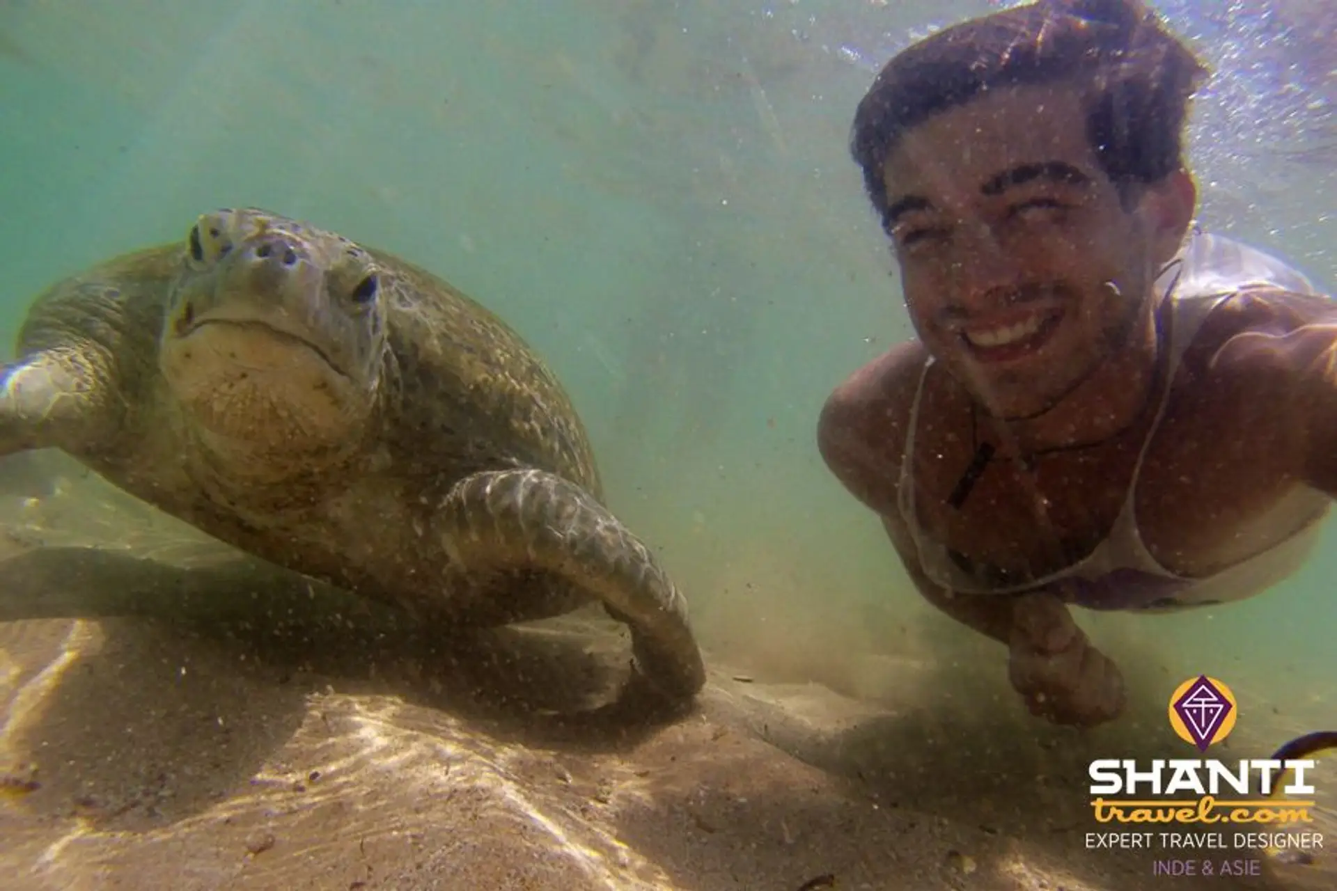 Travel in Asia - A man smiling while swimming next to a sea turtle off the coast of Sri Lanka