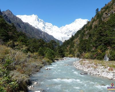 Travel in Asia - A river running through an alpine setting with snow-capped Himalayan peaks in the background