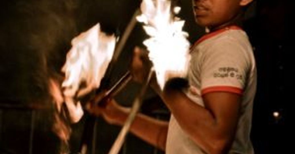 Travel in Asia - A fire performer juggling flaming poi