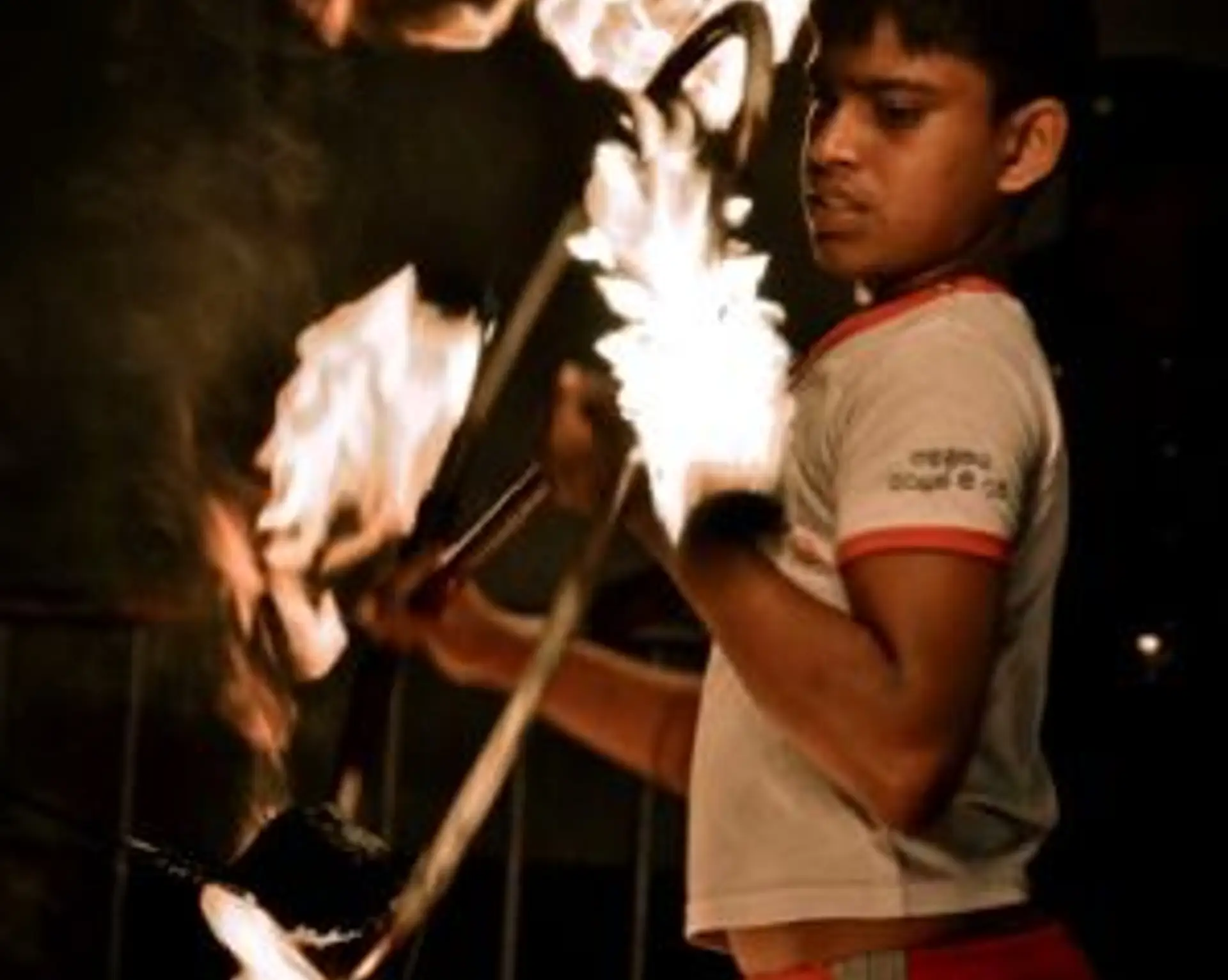 Travel in Asia - A fire performer juggling flaming poi