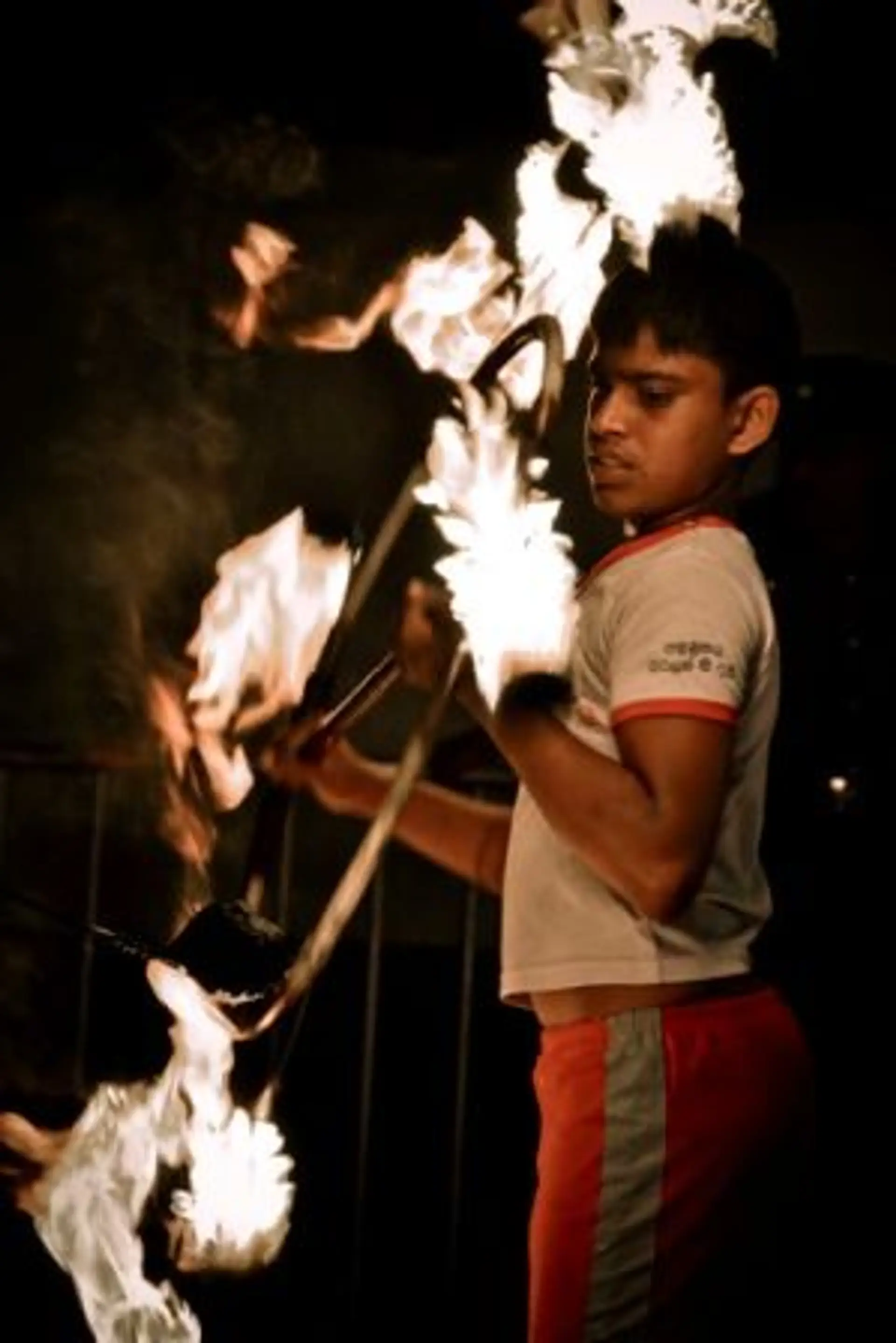 Travel in Asia - A fire performer juggling flaming poi