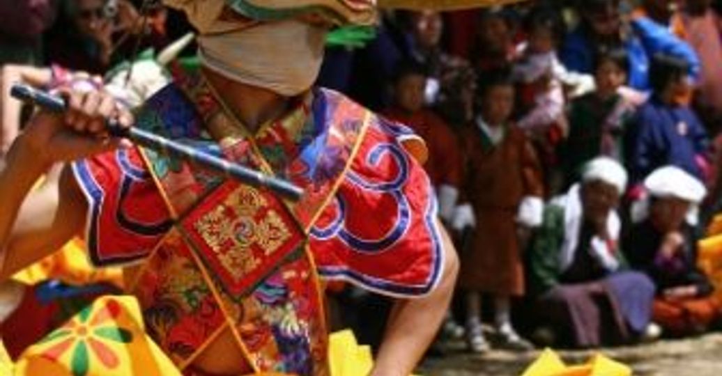 Travel in Asia - Dancer in a vibrant costume at the Tshechu festival in Bhutan