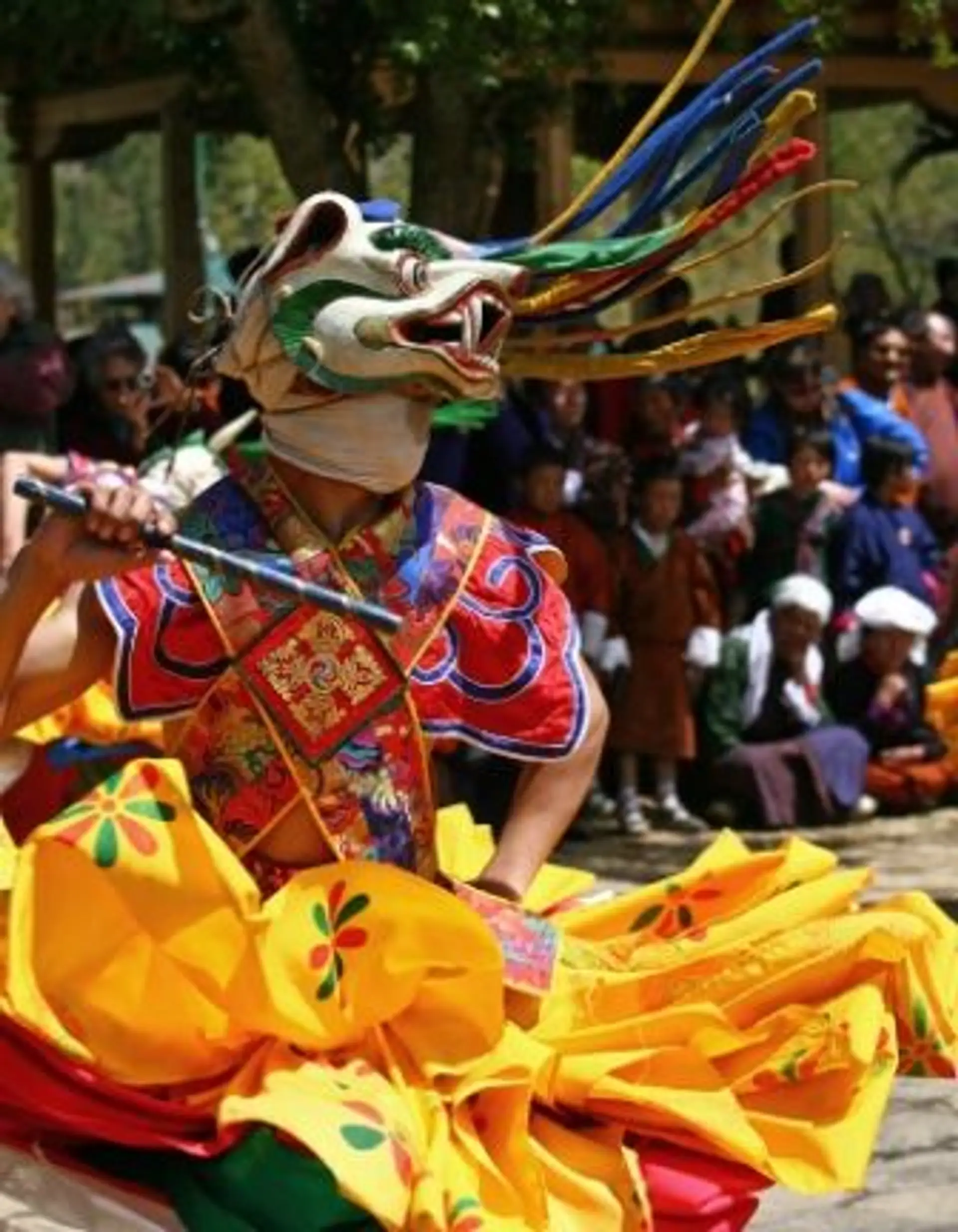 Travel in Asia - Dancer in a vibrant costume at the Tshechu festival in Bhutan