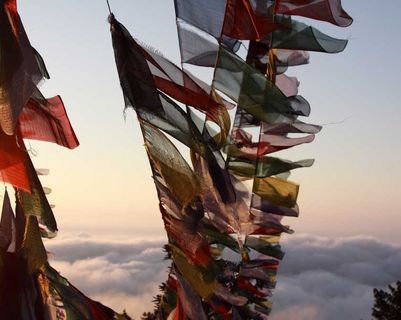 Travel in Asia - Prayer flags blowing in the wind high above the clouds in Nepal