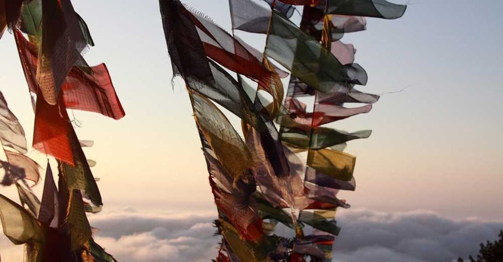 Travel in Asia - Prayer flags blowing in the wind high above the clouds in Nepal