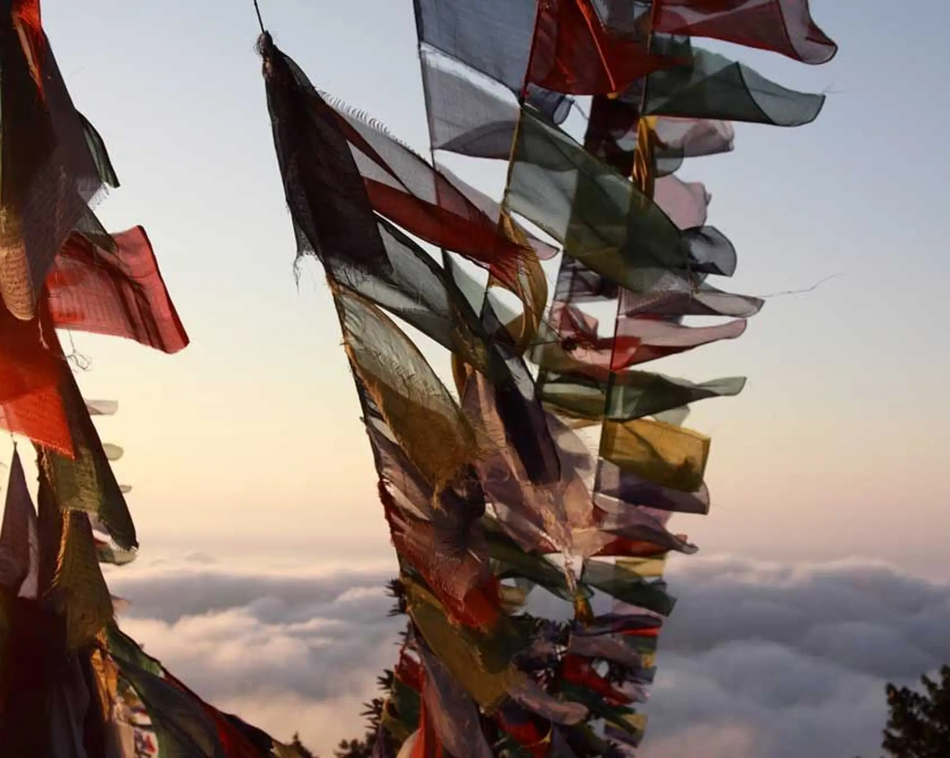 Travel in Asia - Prayer flags blowing in the wind high above the clouds in Nepal