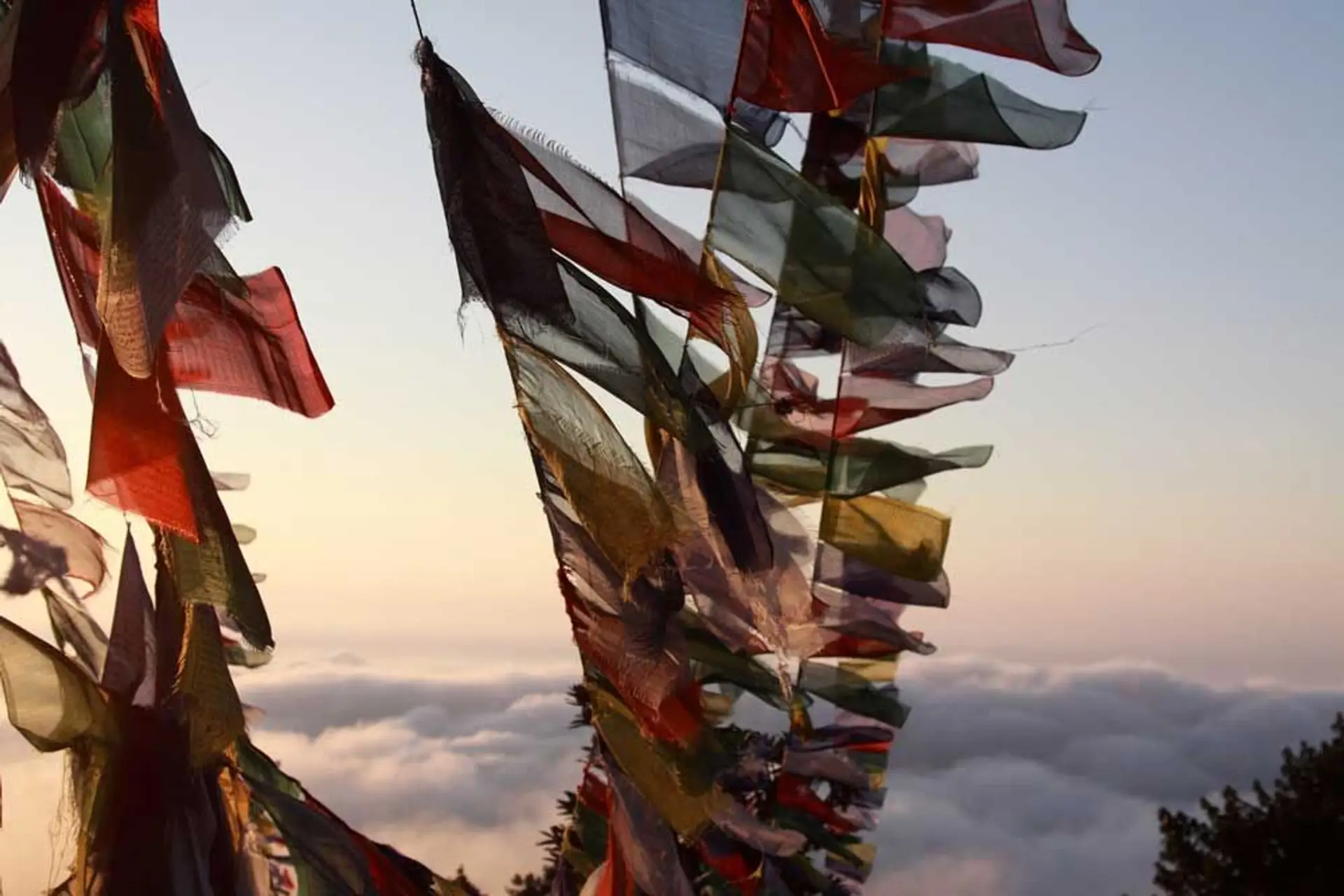 Travel in Asia - Prayer flags blowing in the wind high above the clouds in Nepal