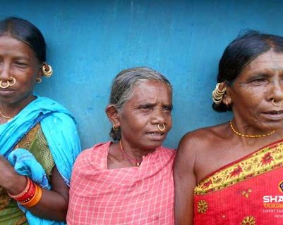 Travel in Asia - Three women standing against a blue wall in traditional clothing in Odisha