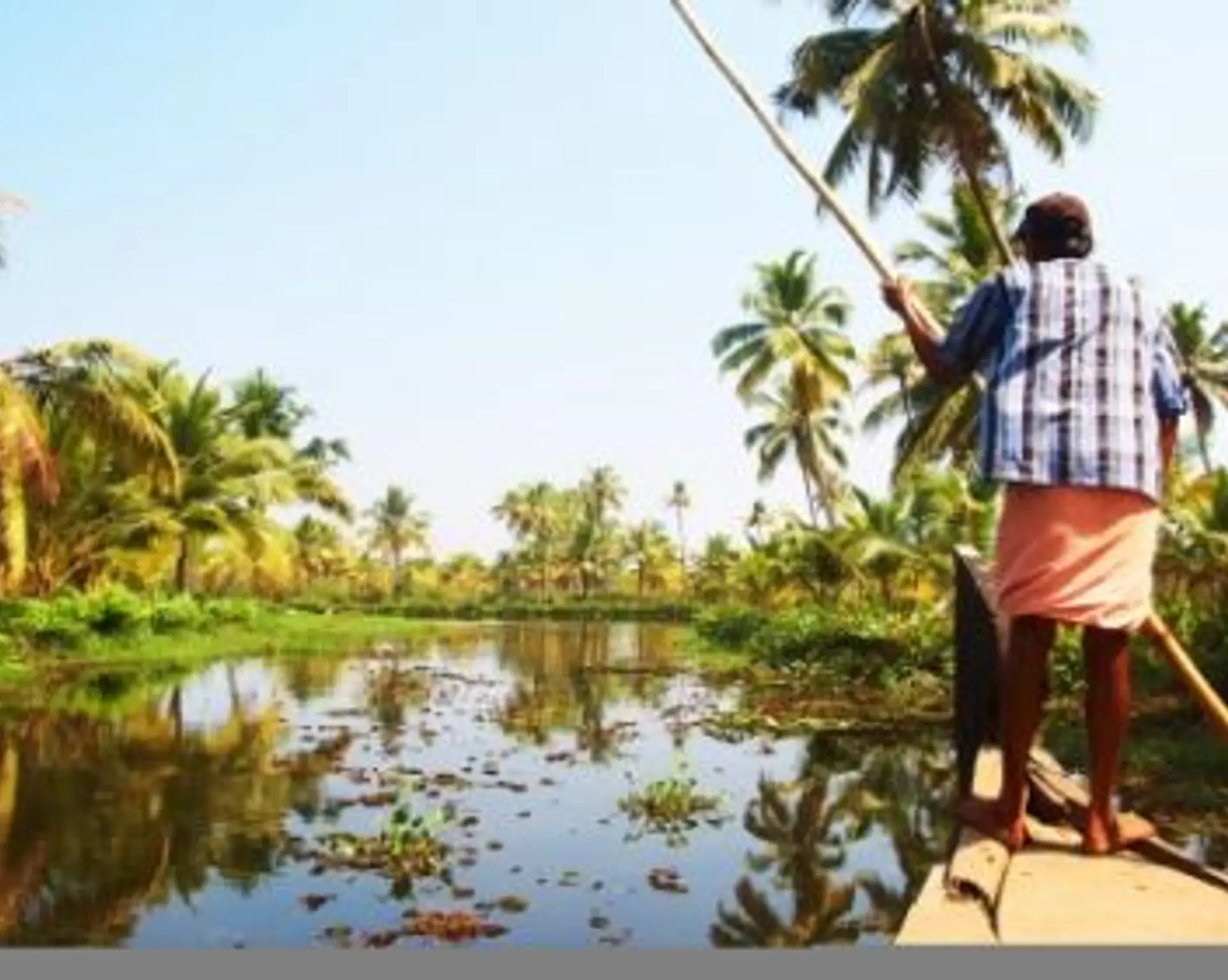 Travel in Asia - Man guiding a boat on the backwaters of Kerala, India