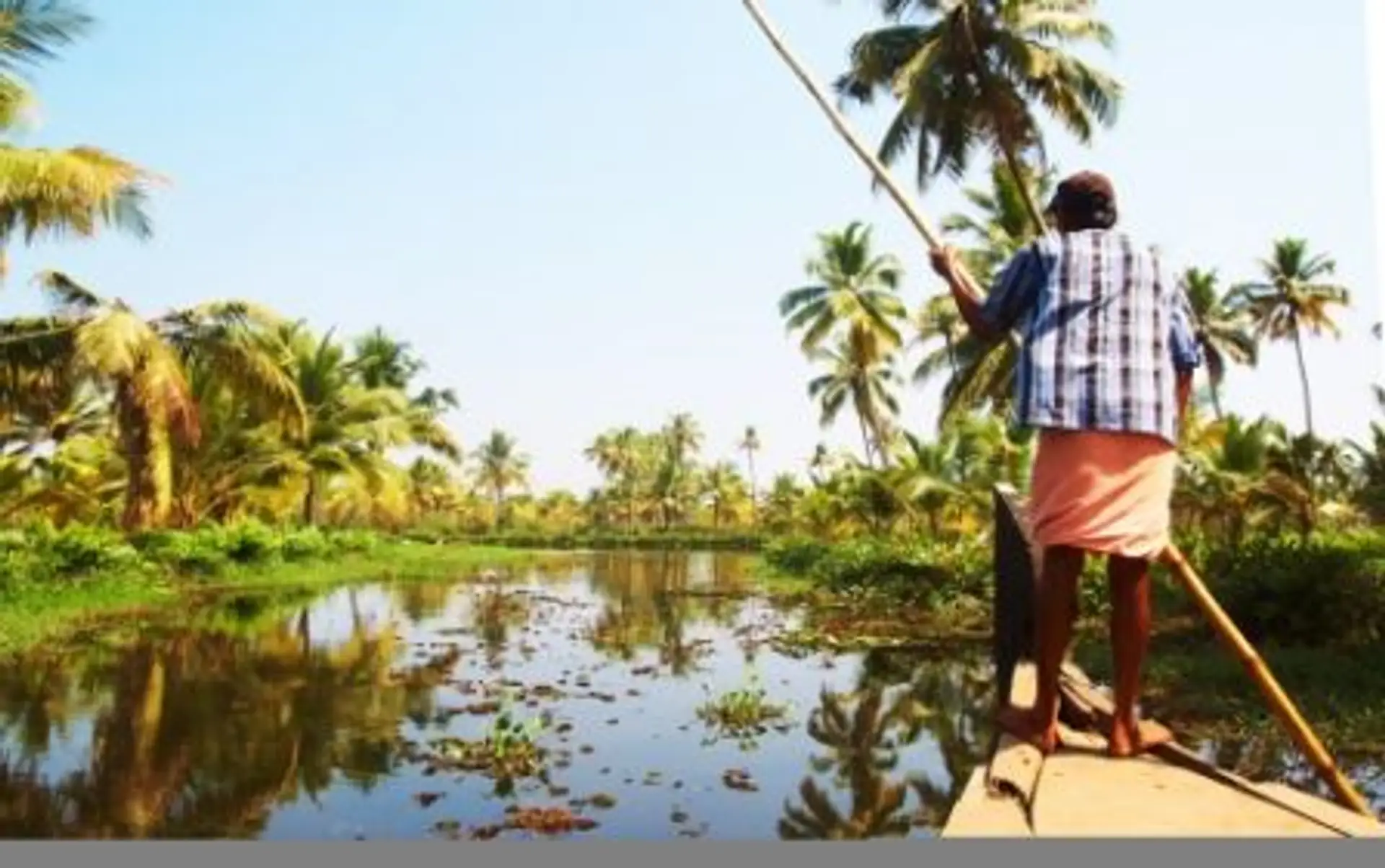 Travel in Asia - Man guiding a boat on the backwaters of Kerala, India